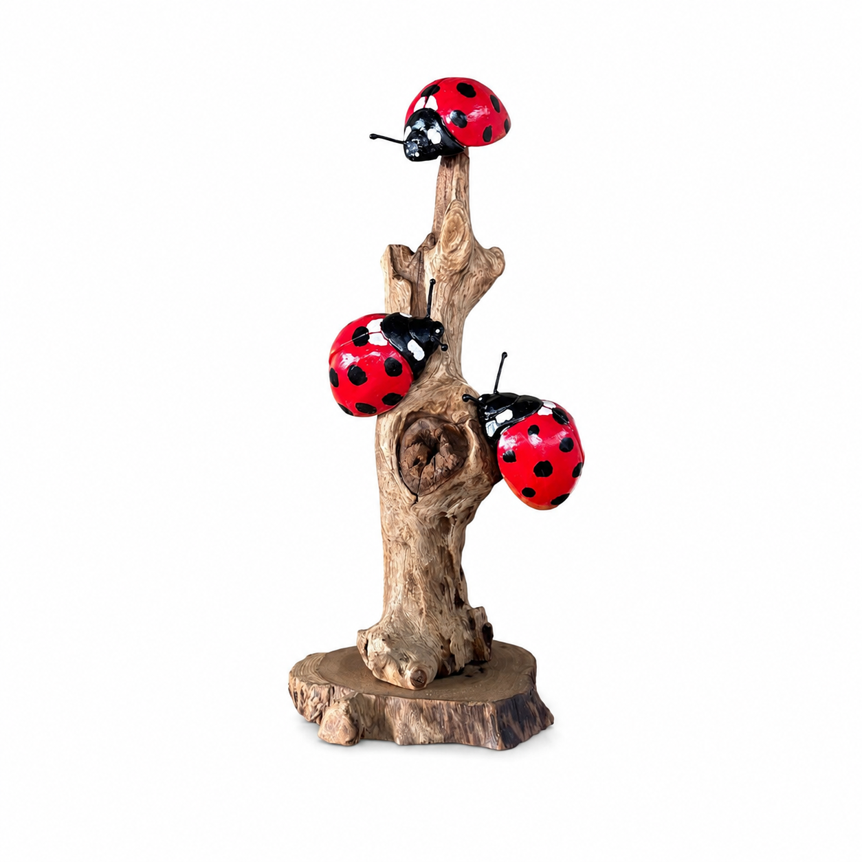 Handcrafted wooden ladybug sculpture on a natural wood branch