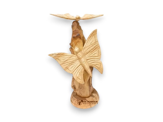 Two hand-carved wooden butterflies with detailed wings displayed on a natural rootwood trunk