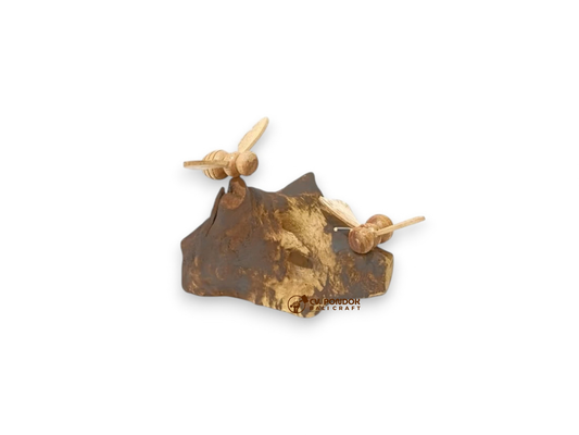 Two miniature hand-carved wooden bees resting on a naturally shaped dark wooden base