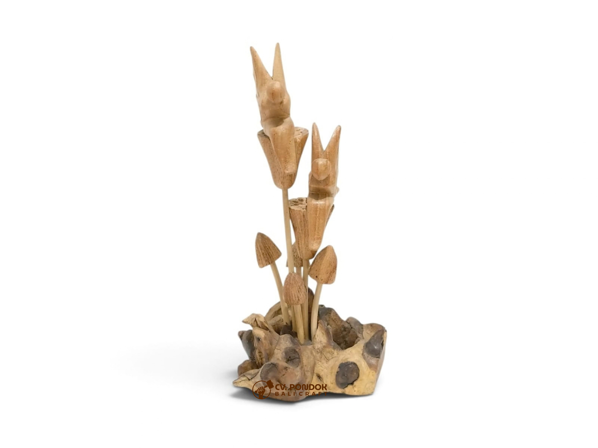 Two hand-carved wooden winged fairies sitting on tall flowers above a mushroom cluster